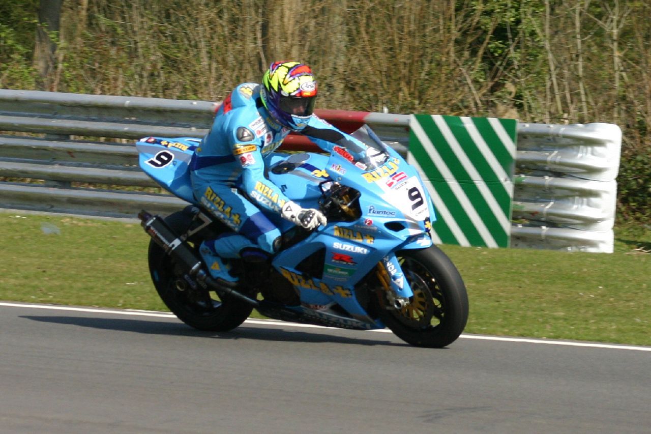 a man riding on the back of a blue motorcycle