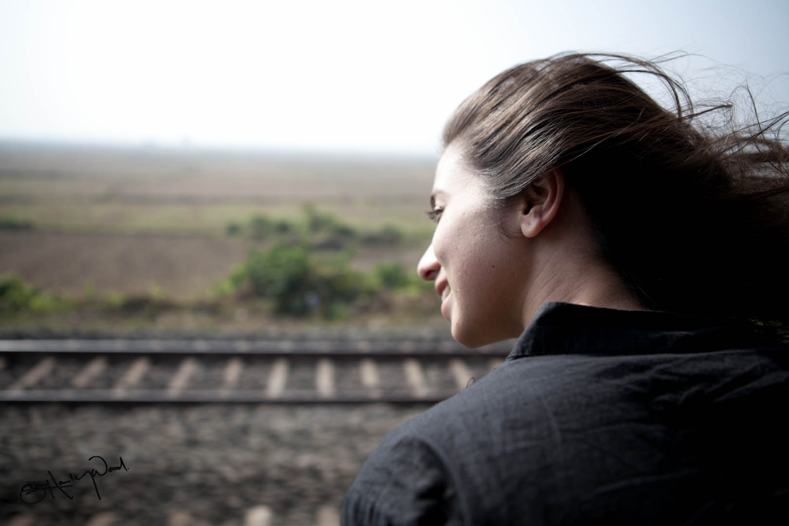 a woman standing on a train track facing the right