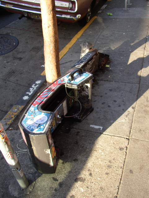 a broken up parking meter sitting next to a traffic light