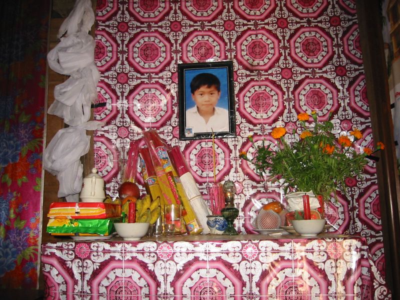 a portrait of a young man hangs above the kitchen sink