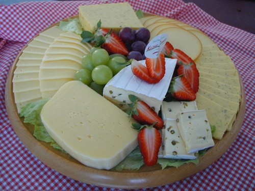 many cheeses, fruits, and gs on a platter