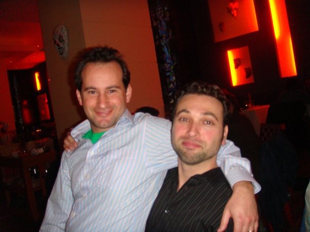 two men are posing for the camera in a bar