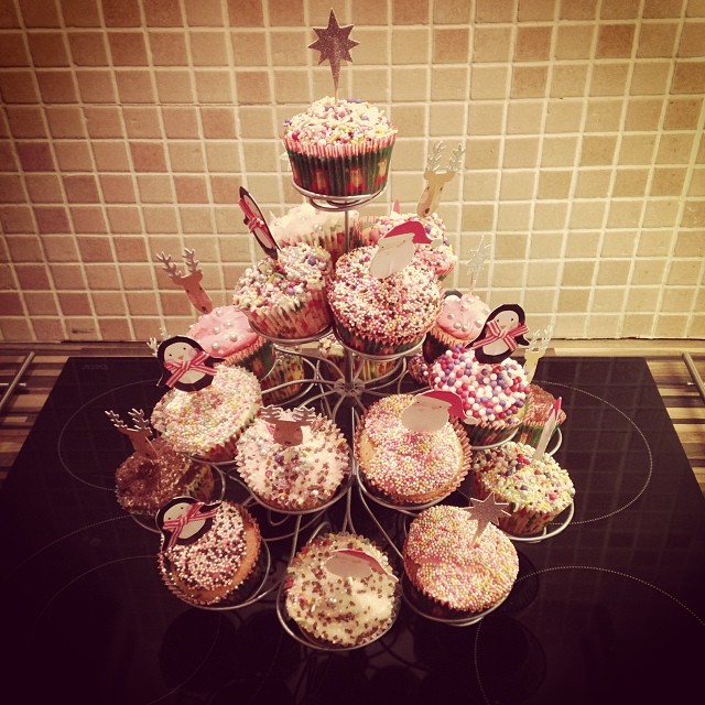 large tower of cupcakes decorated with bows and ribbon