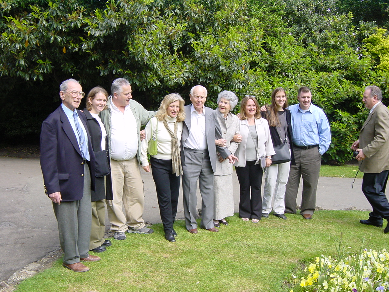 a group of elderly people standing on a grassy area