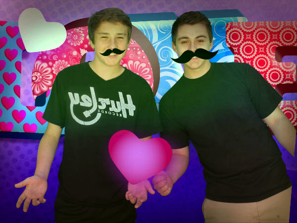 the two friends are wearing funny mustaches and black shirts