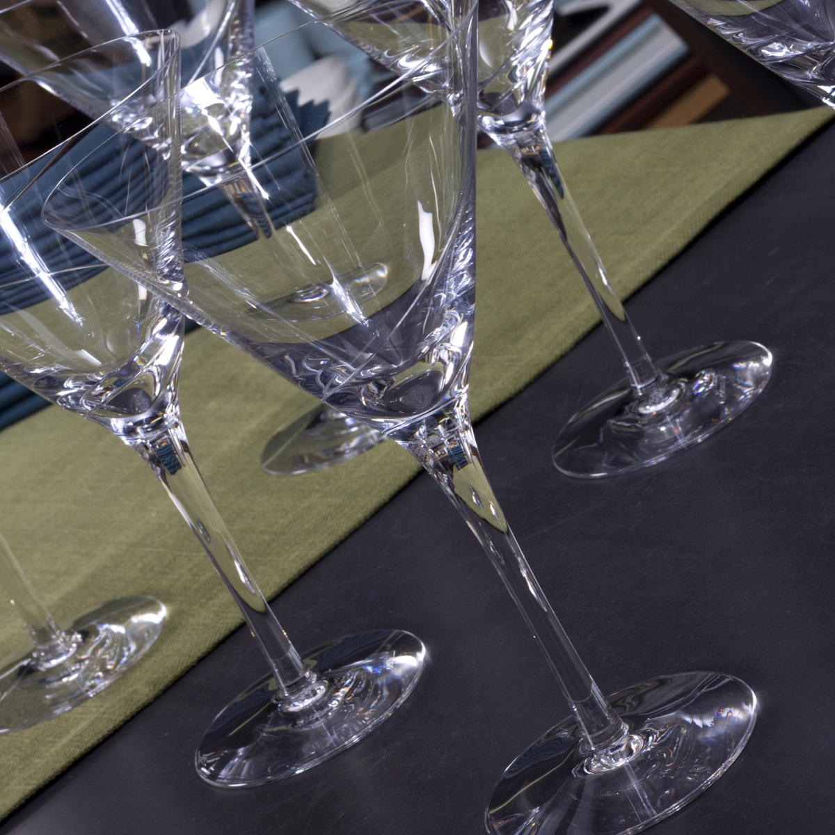 a line of clear champagne flutes on top of a table