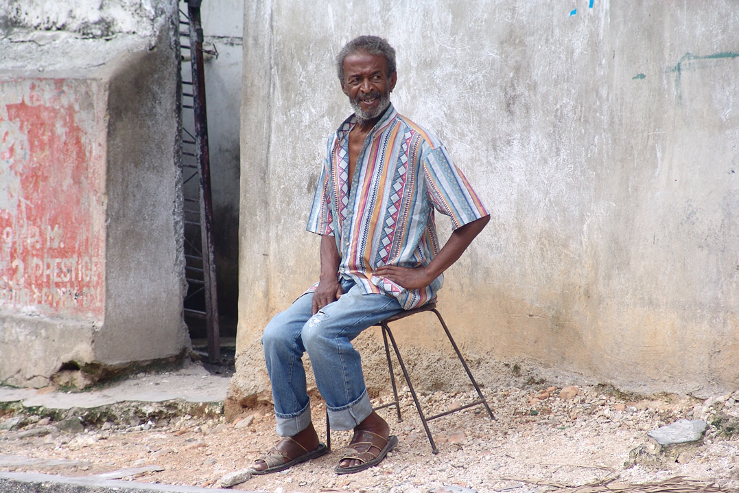 a man sitting on a chair with his feet crossed