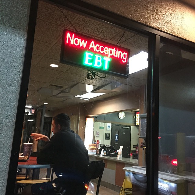 a restaurant with neon sign for now accepting ebi