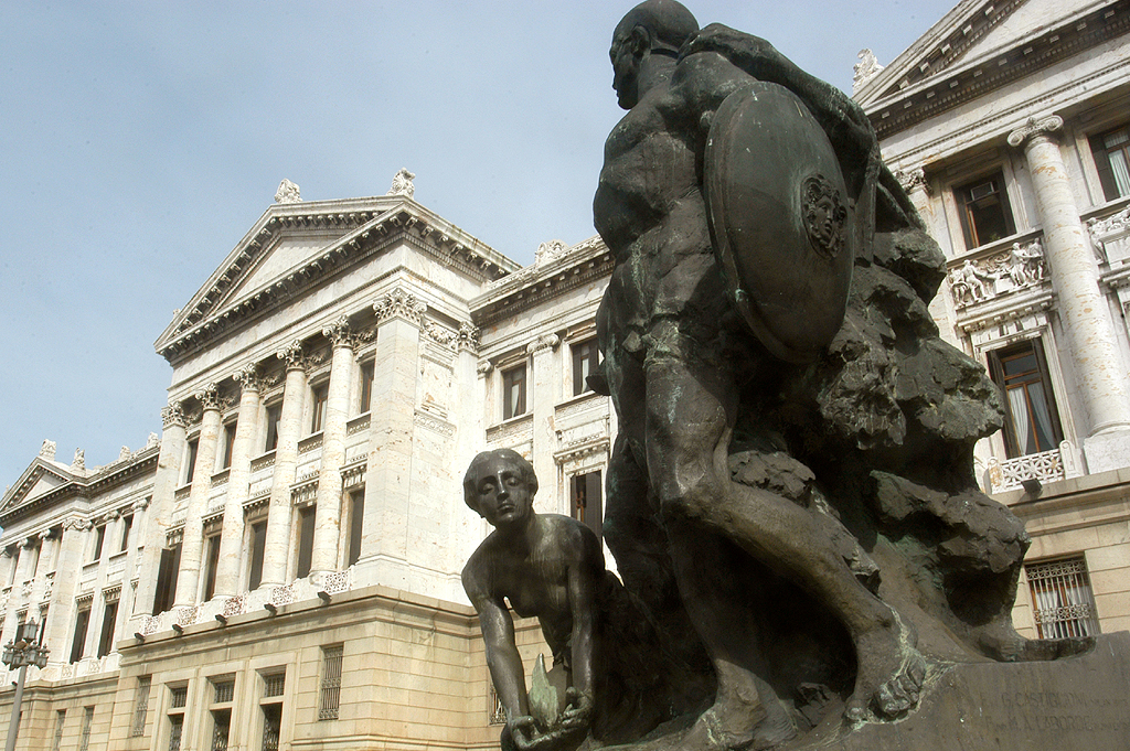 a sculpture of two people with a man walking by