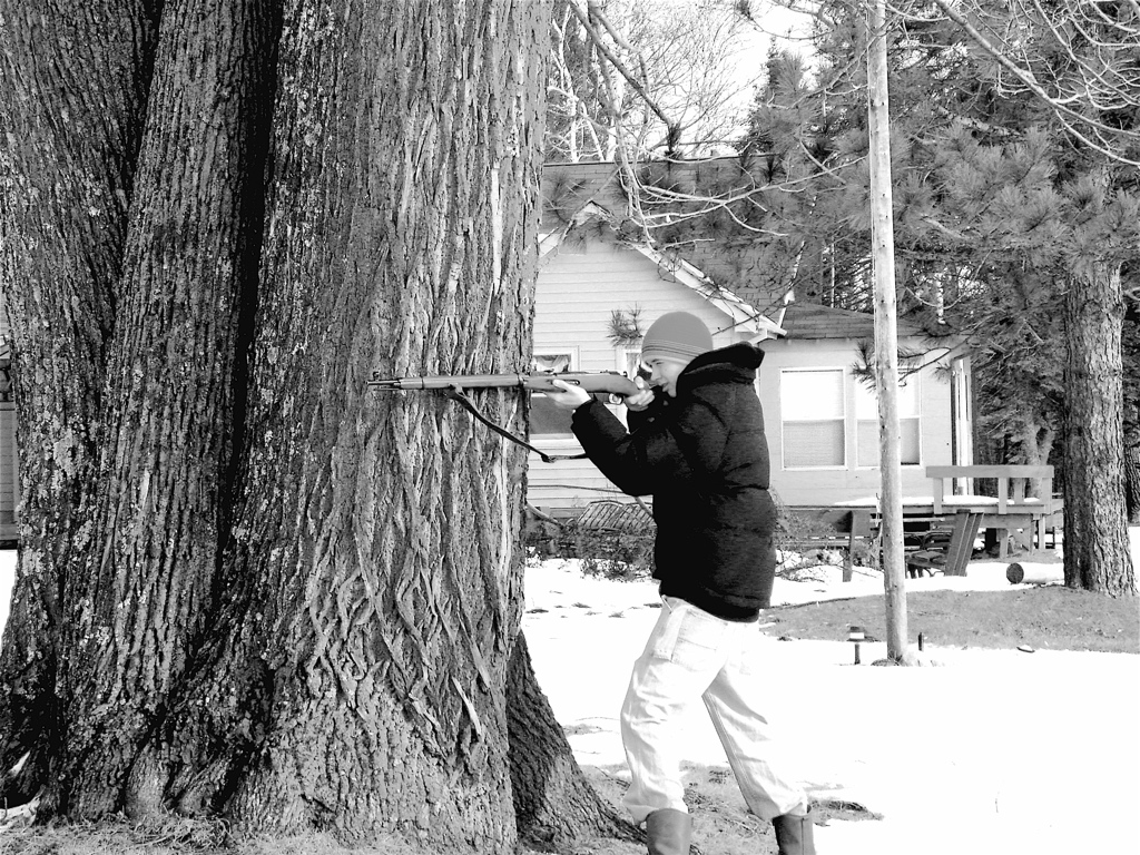 a man on a snowboard near a tree in front of a house