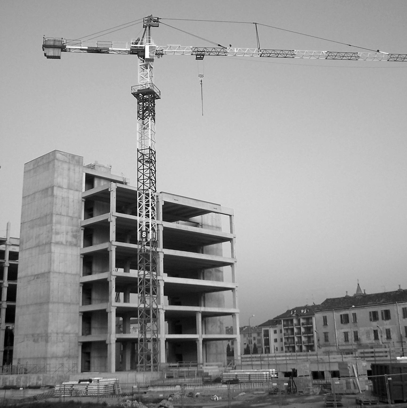 a large crane is standing next to a very tall building