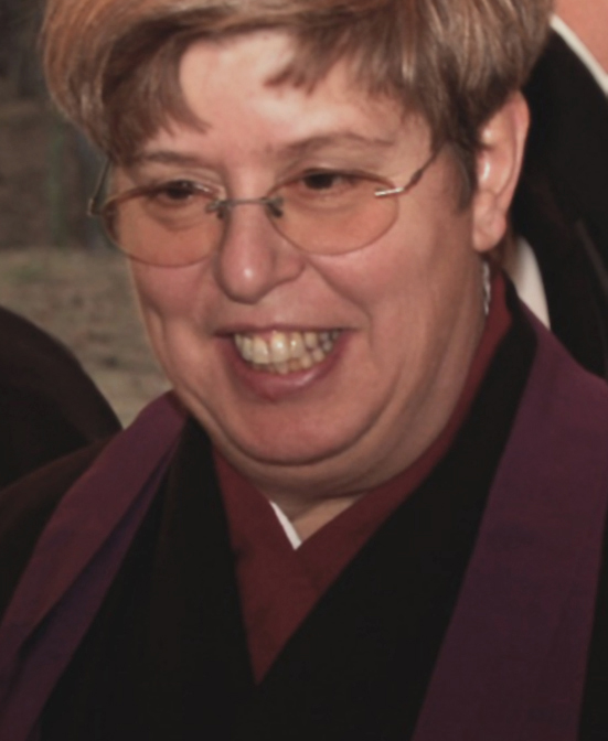 a woman in glasses with hair in a smiling manner