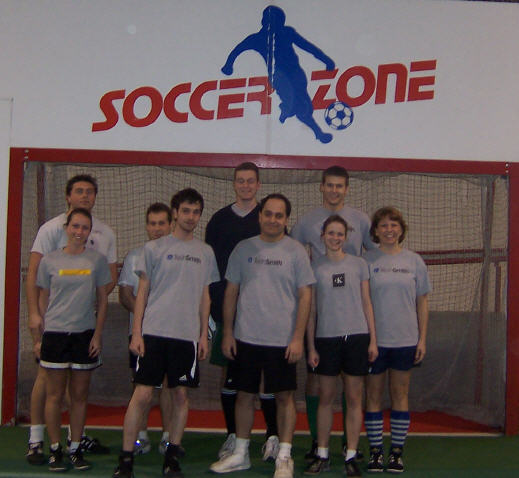 a group of men standing next to each other with a soccer goal in front of them