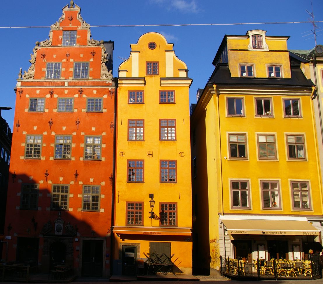 a row of different colored buildings on the street