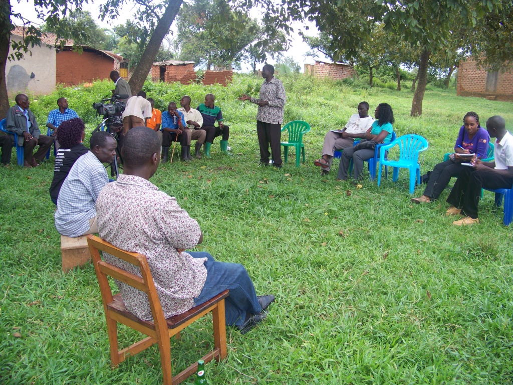 a group of people sit in a circle on chairs