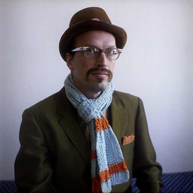 the man is wearing a hat, scarf and glasses