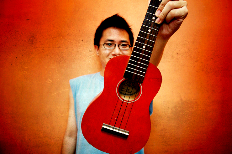 a woman with glasses holding a red guitar