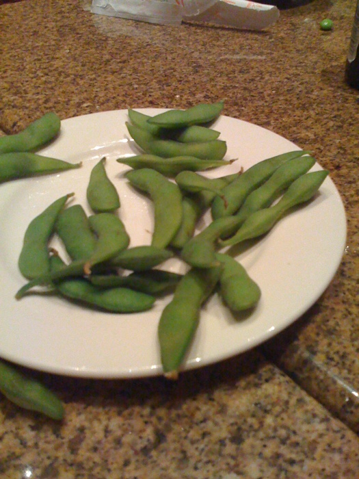 peas are placed on a white plate on the counter