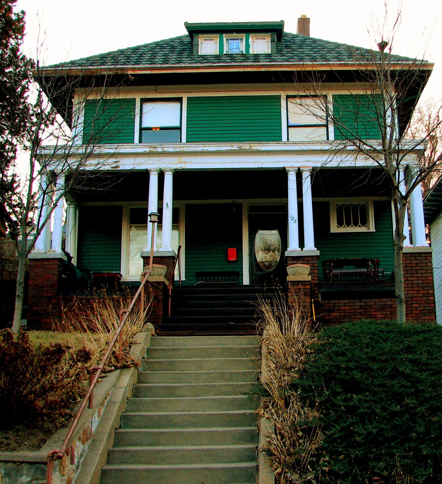 green house with porch and stairs on the side