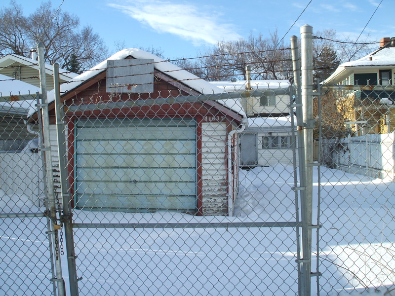 a chain link fence with a house and garage
