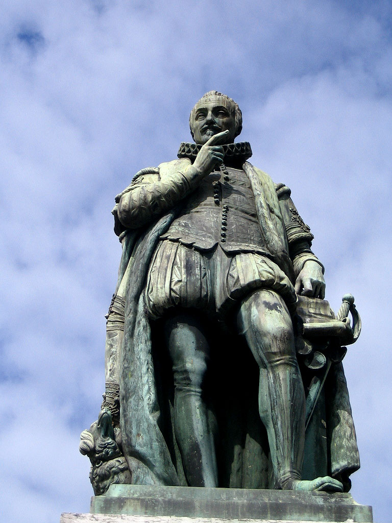 a statue of a man sitting on top of a stone