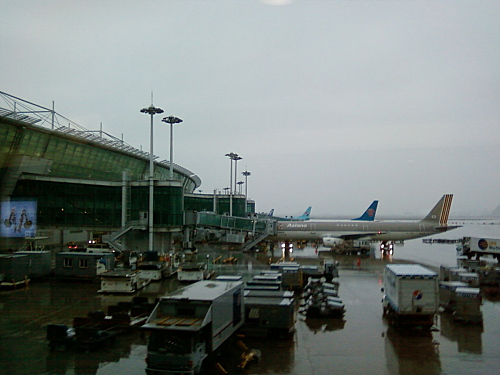 several airplanes are parked next to the airport in the rain
