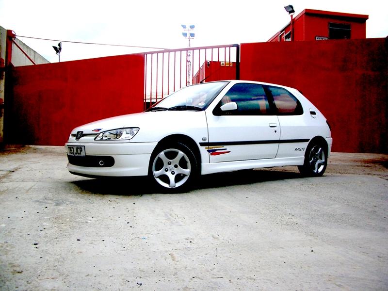 a white car in front of a red wall