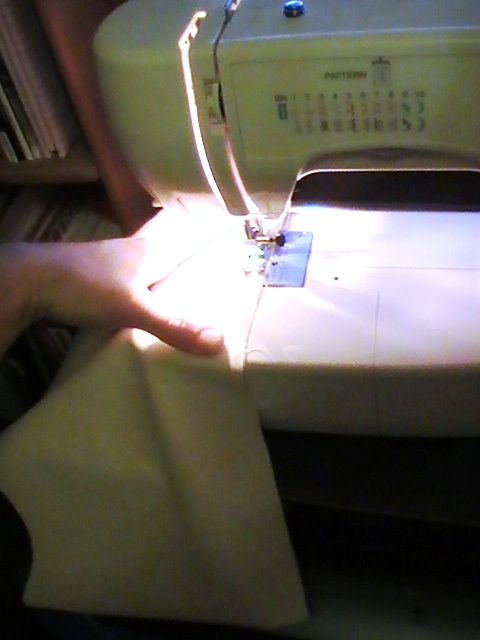 person's hands in front of a sewing machine