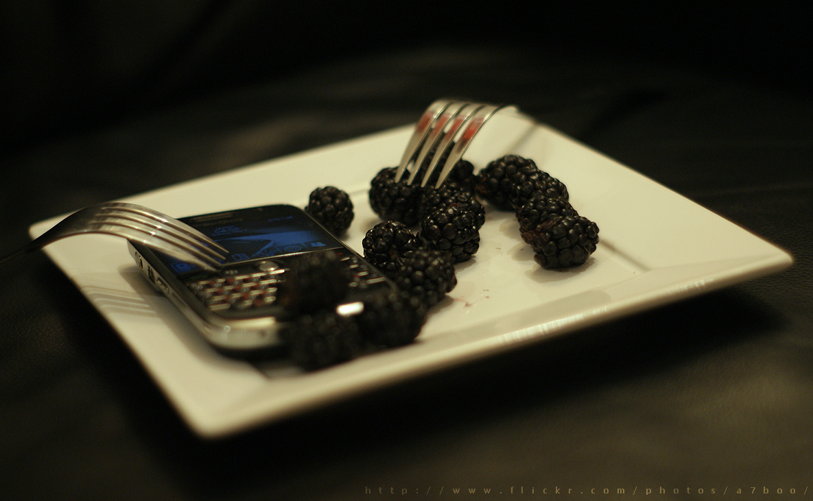 a plate with a cell phone and fork on it