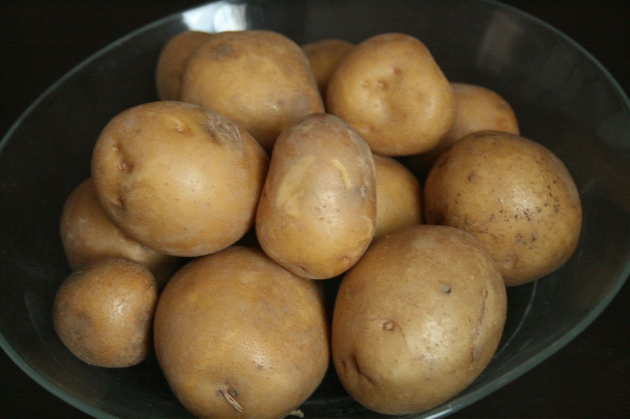 some yellow potatoes sitting in a glass bowl