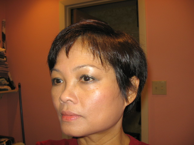 a woman with short hair wearing a red shirt and looking away from the camera