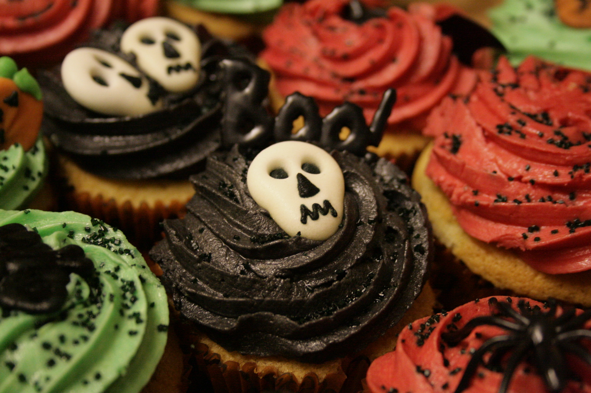 many decorated cupcakes on display in a box