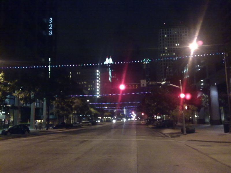 an empty street is lit up with a red traffic light