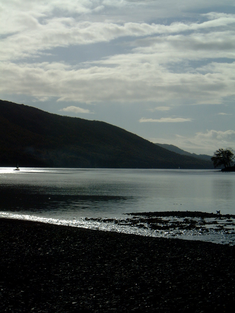 a man walking along a beach next to the water