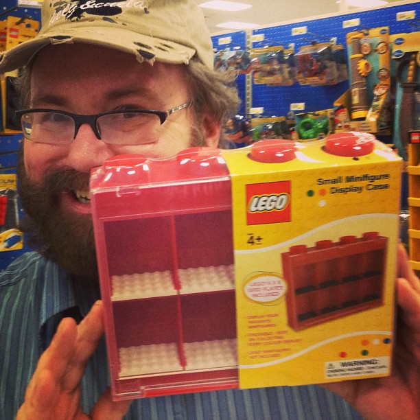 man holding a lego boxed box in a store