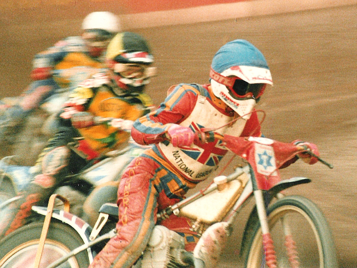 three motorcycle riders with helmets and goggles racing on their bikes