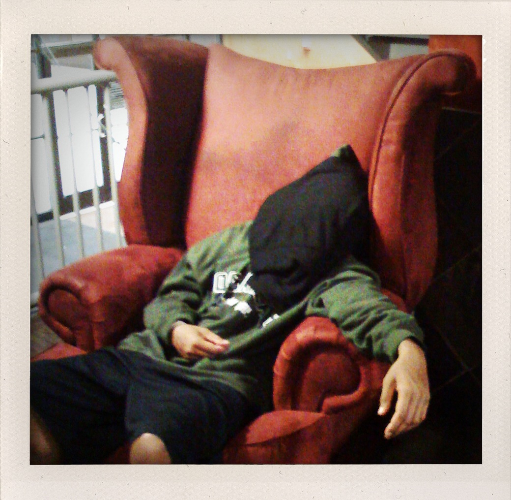 a man is asleep on the red couch