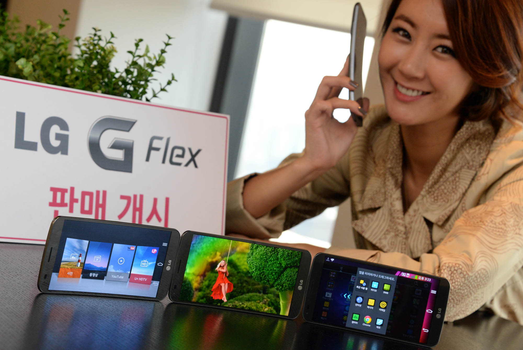 the woman is displaying her cell phone, which is designed as an lg flex