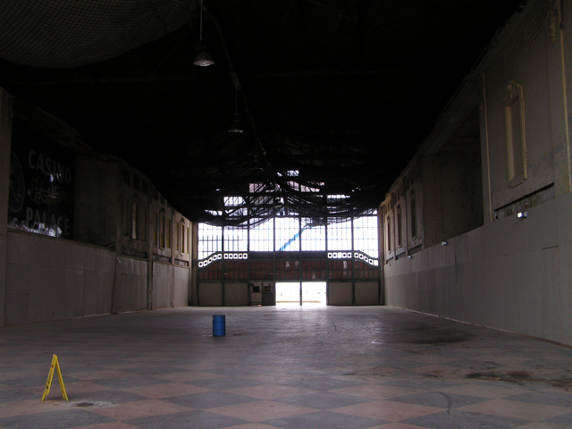 an empty building with windows, a checkered floor, and a cone - shaped skylight