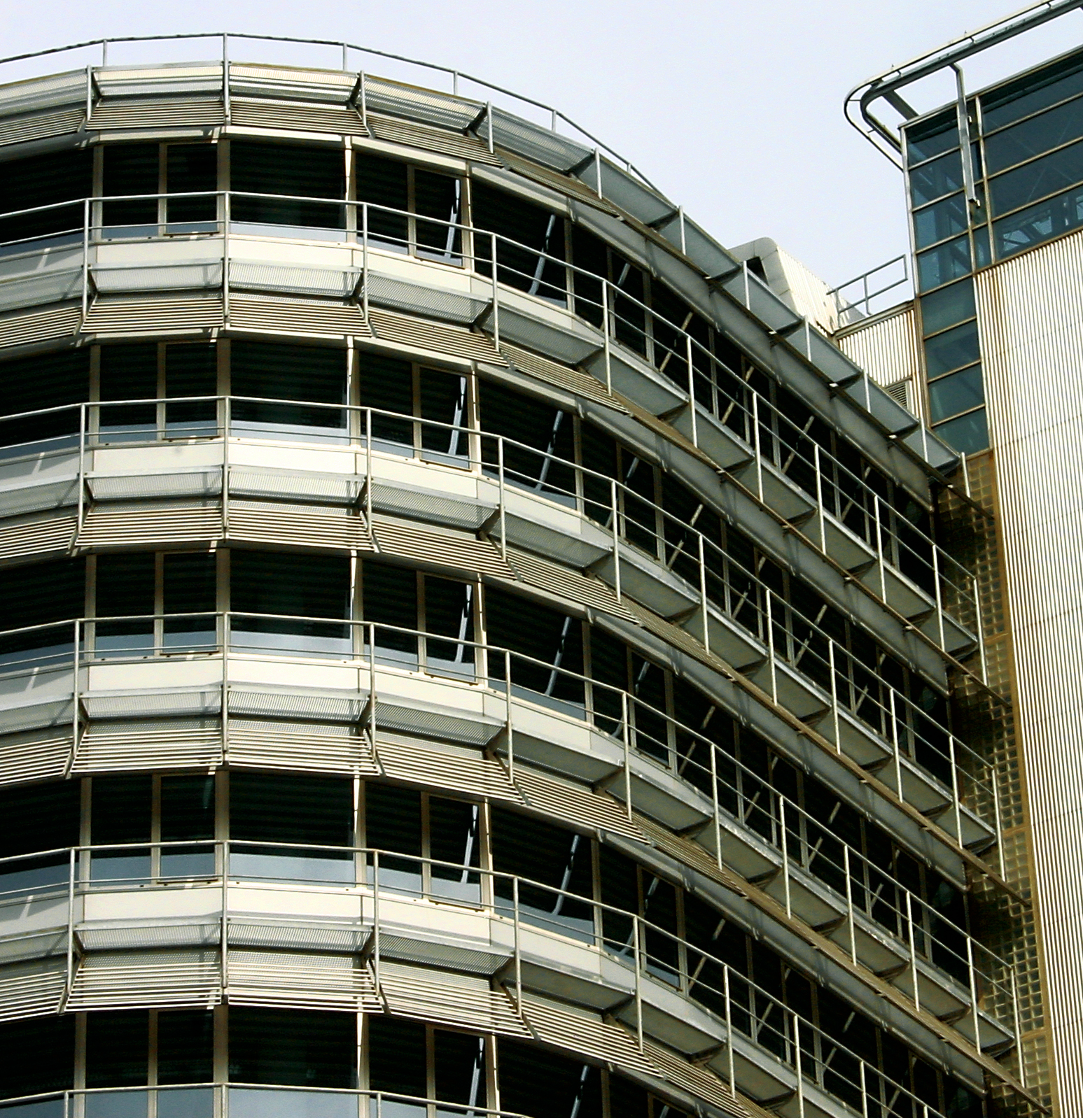 a large curved building is in front of a clock tower