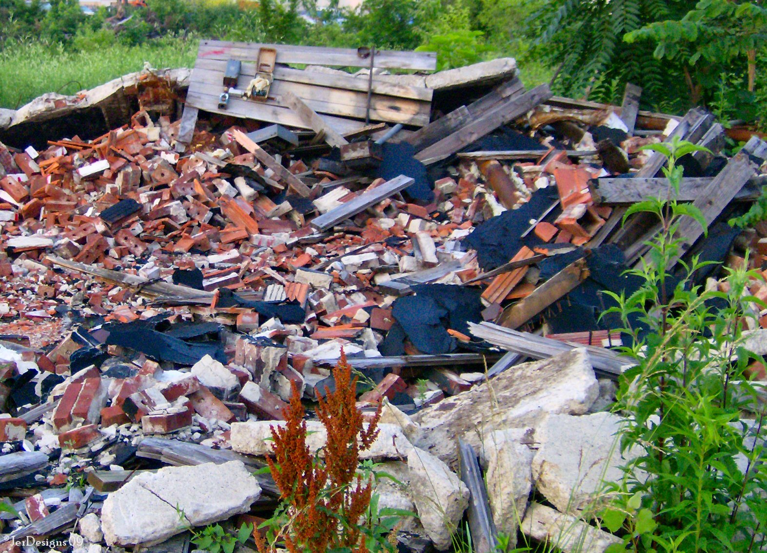 a pile of rubble next to a wooded area