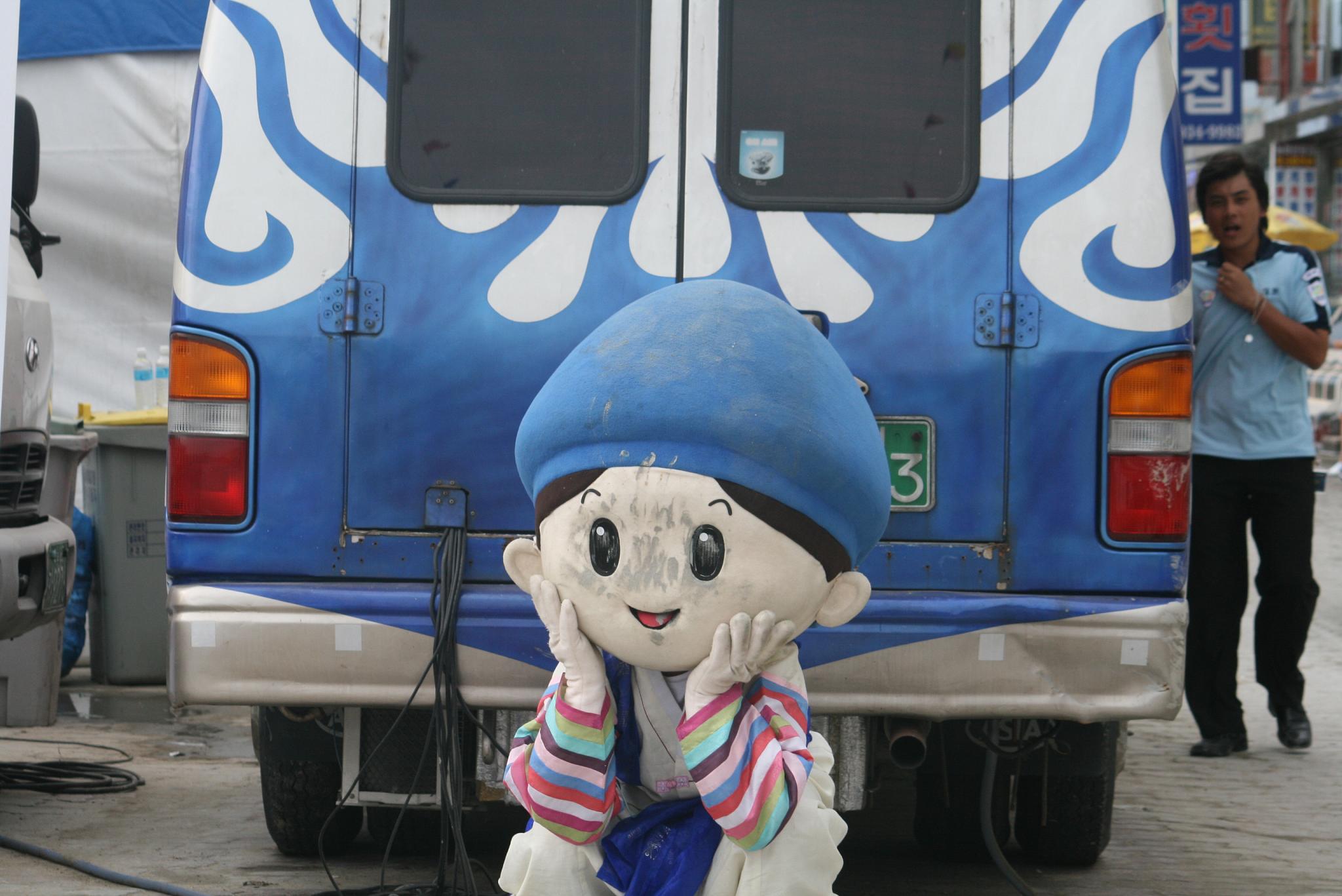 a man with a blue hat standing by a bus