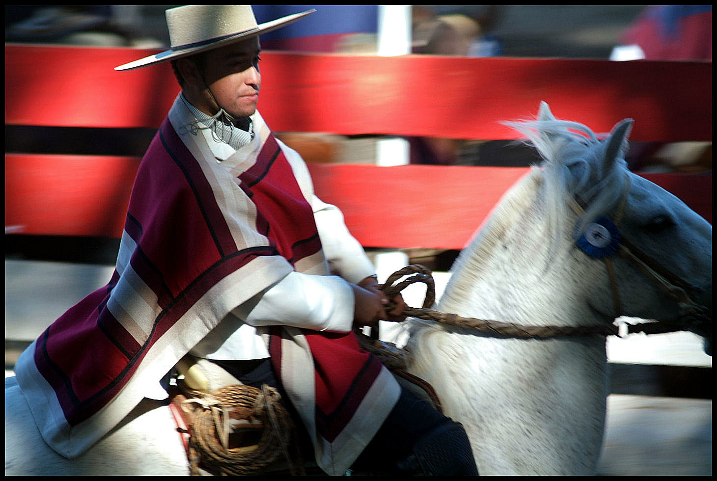 a man in a hat and coat riding a white horse