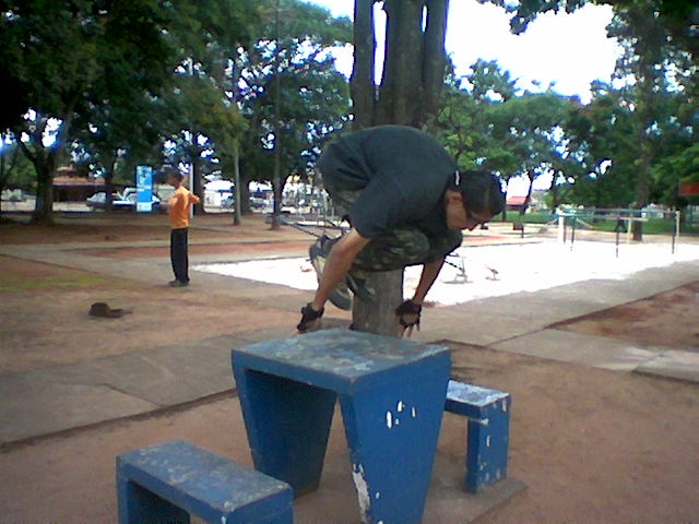 a skateboarder is performing tricks on a bench