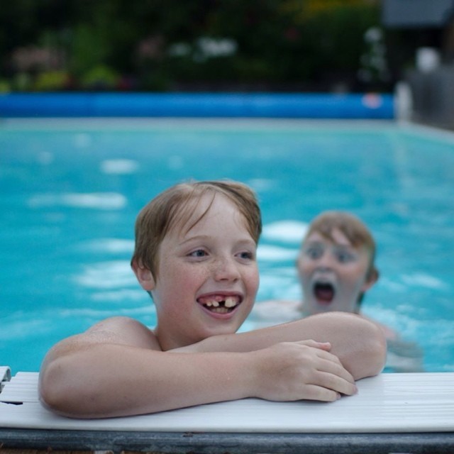 a  and an older person are smiling while in the swimming pool