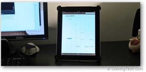 an ipad is turned on sitting on the desktop next to another computer monitor