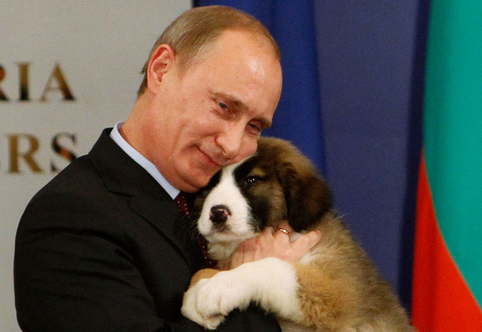 a russian president hugging a puppy while posing for a picture