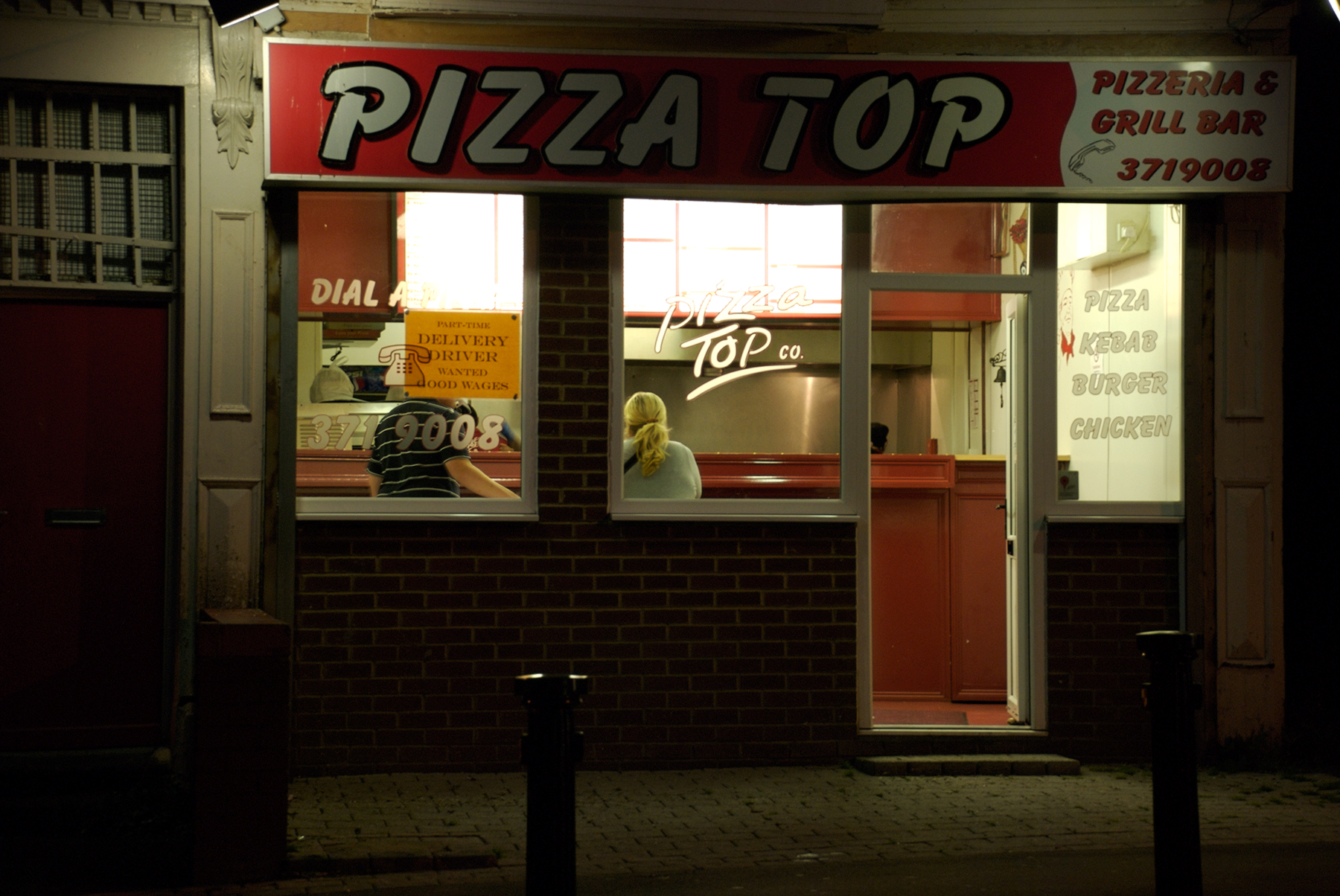 a pizza shop with a red sign on the door