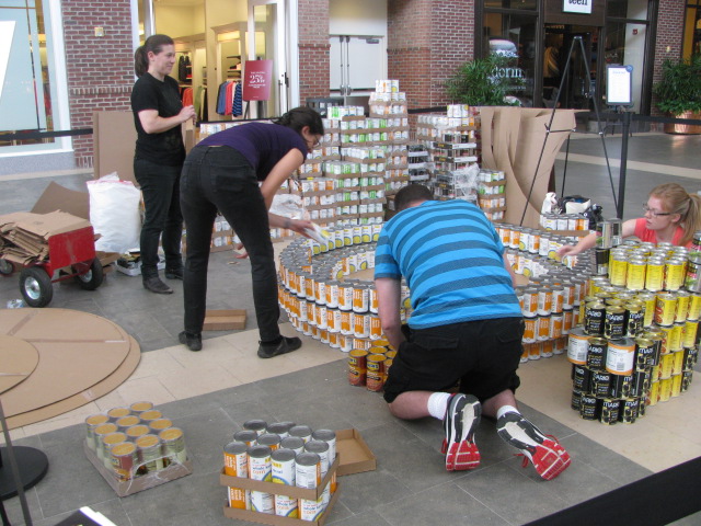 two men are arranging cans of beer together