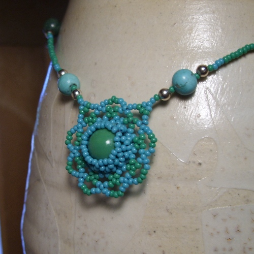 a blue necklace is made from beads on a mannequin